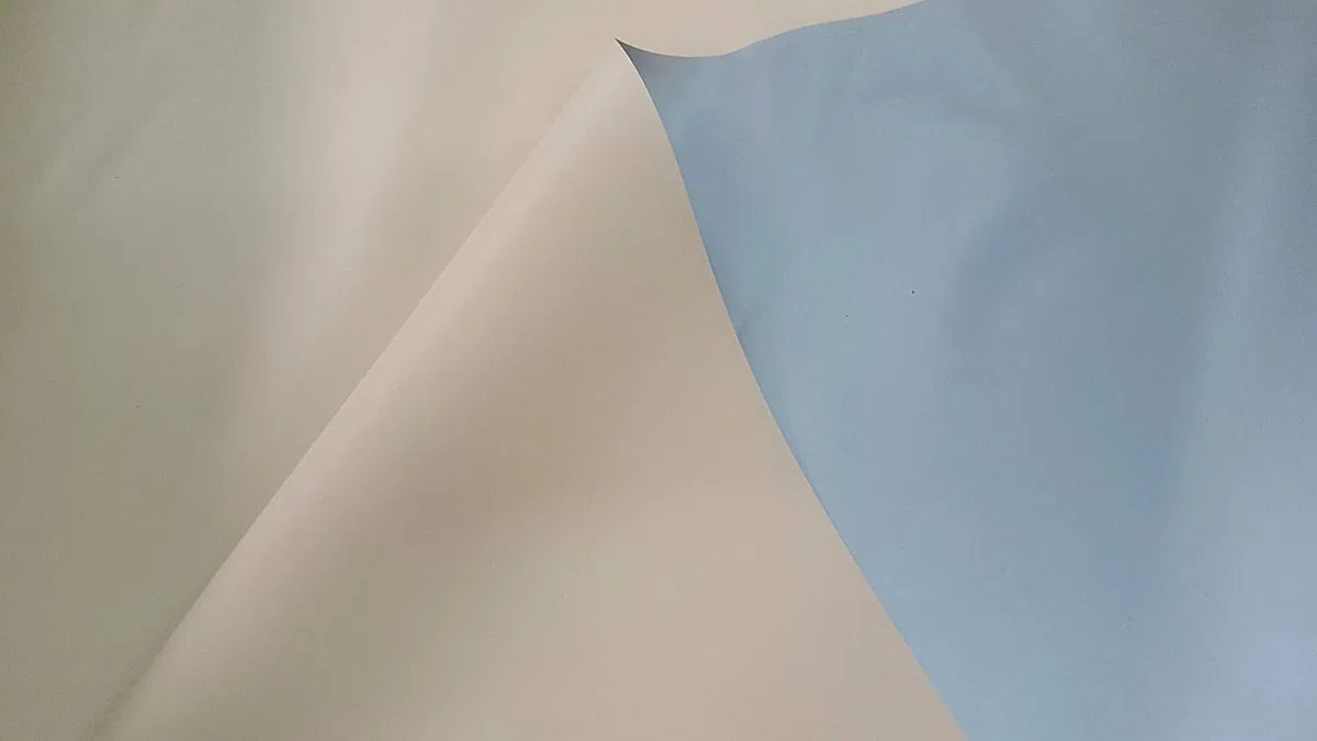PVC impermeable, pvc opaco y ignifugo. Ancho de 210 cm. Por una cara de color gris y por la otra de color beig