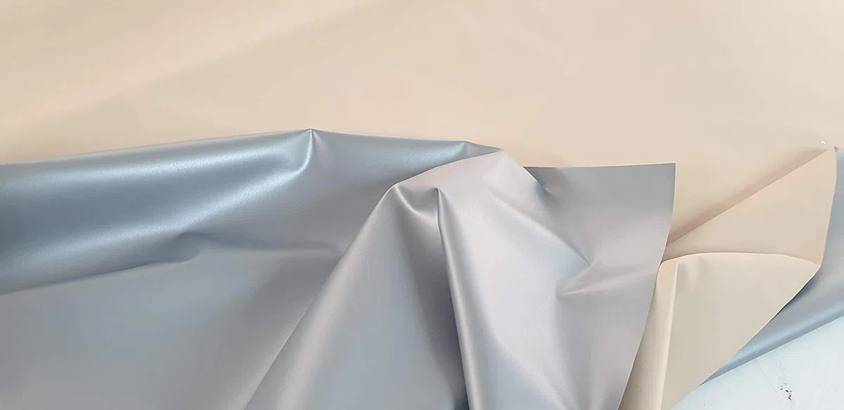 PVC impermeable, pvc opaco y ignifugo. Ancho de 210 cm. Por una cara de color gris y por la otra de color beig