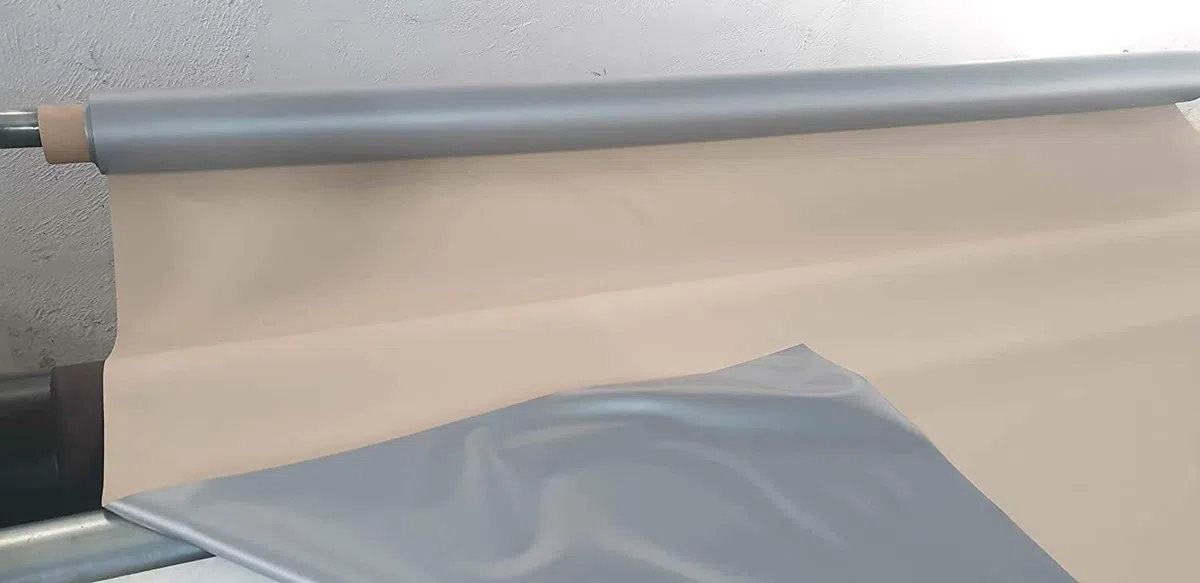 PVC impermeable, pvc opaco y ignifugo. Ancho de 210 cm. Por una cara de color gris y por la otra de color beig